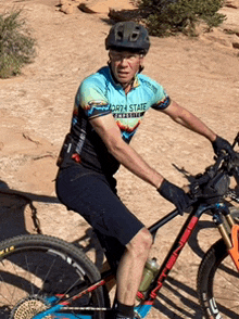 a man wearing a north state shirt is riding a bike