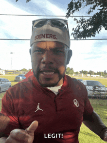 a man wearing a sooners hat and a maroon shirt