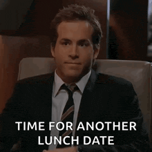 a man in a suit and tie is sitting in a chair and saying time for another lunch date .