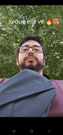 a man with glasses and a beard is holding a black bag that says timothy on it