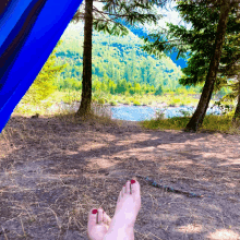 a person laying in a hammock with their feet on the ground