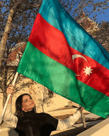 a woman is holding up a flag with a white star on it