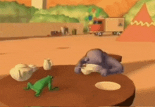 a frog sits on a table next to a purple gorilla eating a bowl of food