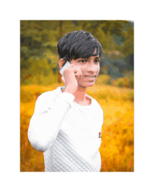 a young man in a white sweater is talking on his cell phone