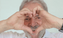 a man with a beard is making a heart with his hands