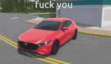 a red car is parked on the side of the road with the words " fuck you " written above it