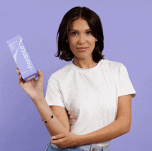 a woman in a white shirt is holding a box that says florence on it