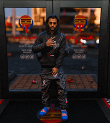 a man in a black hoodie stands in front of a window with a hamburger icon