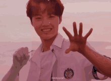 a young man in a school uniform is smiling and giving a high five