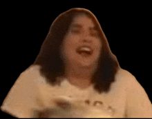 a woman in a white t-shirt is laughing with her mouth open