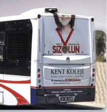 the back of a kent koleji bus with a girl on it