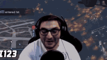 a man wearing glasses and headphones is playing a video game with the number 1123 on the screen