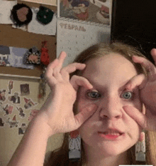 a girl making a face with her hands in front of a calendar that says february