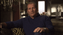 a man wearing a watch is sitting with his eyes closed