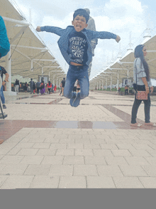 a boy wearing a born to play bart shirt jumps in the air