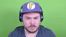 a man wearing headphones and a purple hat with a yellow letter g on it