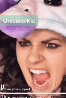 a woman wearing a unicorn hat is making a face