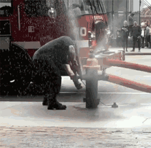 a fireman is working on a fire hydrant in front of a fire truck with the number 10 on the front