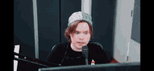 a man wearing a bandana is sitting in front of a computer screen