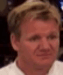 a close up of a man 's face in a white shirt .