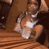 a woman is sitting at a table drinking water from a bottle .