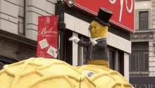 a statue of a peanut wearing a top hat and glasses is sitting on top of a waffle .