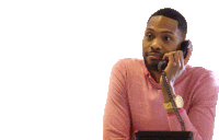 a man in a pink sweater talking on a phone