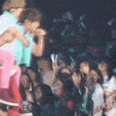 a crowd of people are watching a man sing into a microphone .