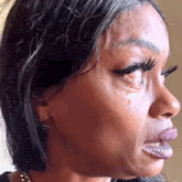 a close up of a woman 's face with tears coming out of her eyes