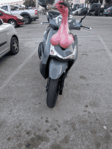 a gray scooter with a pink ostrich on top of it