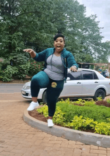 a woman is standing on one leg in front of a car