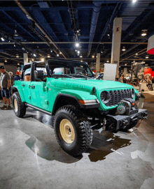 a green jeep is on display in a convention hall