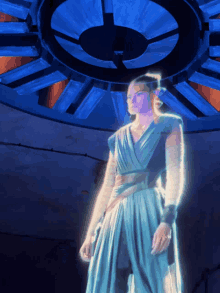 a woman in a blue dress is standing in front of a blue circular object