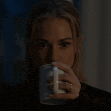 a close up of a woman drinking from a mug