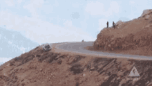 a car is driving down a curvy road on a mountain .