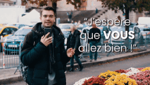 a man standing in front of a bunch of flowers with the words " j'espere que vous allez bien "