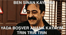 a man with a mustache is smiling in front of a sign that says ' ben sinan kayayim ' on it