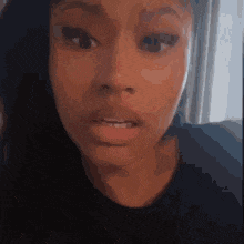 a close up of a woman 's face with a serious expression .