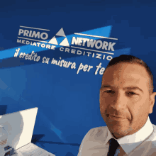 a man is standing in front of a blue wall that says primo network