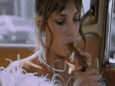 a woman is smoking a cigar while sitting in a car