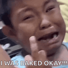 a young boy is crying and giving the middle finger while saying i was baked okay !