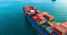 an aerial view of a cargo ship filled with containers floating on top of a body of water .