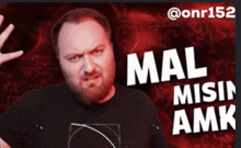 a man with a beard wearing a black shirt that says mal misen amk