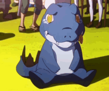 a blue cartoon dinosaur is sitting on the grass