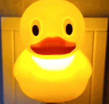 a yellow rubber duck with a smiling face is lit up