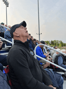 a man sitting in a stadium looking up at something