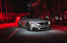 a silver bmw is parked in front of a red building