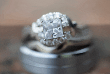 a diamond ring sits on top of a wedding band