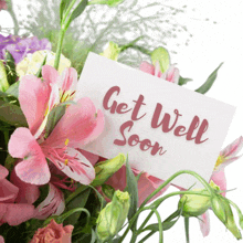 a bouquet of pink and purple flowers with a get well soon card