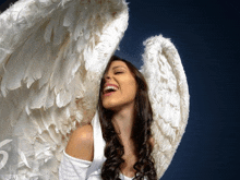 a woman with angel wings is laughing and smiling